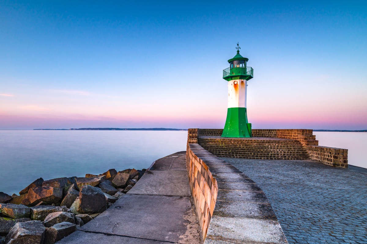 The green-and-white lighthouse at the harbor entrance of Sassnitz on Rügen at dusk