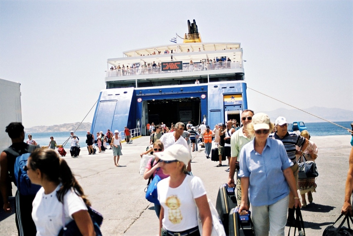 Passengers disembarking a ferry in a Greek harbour
