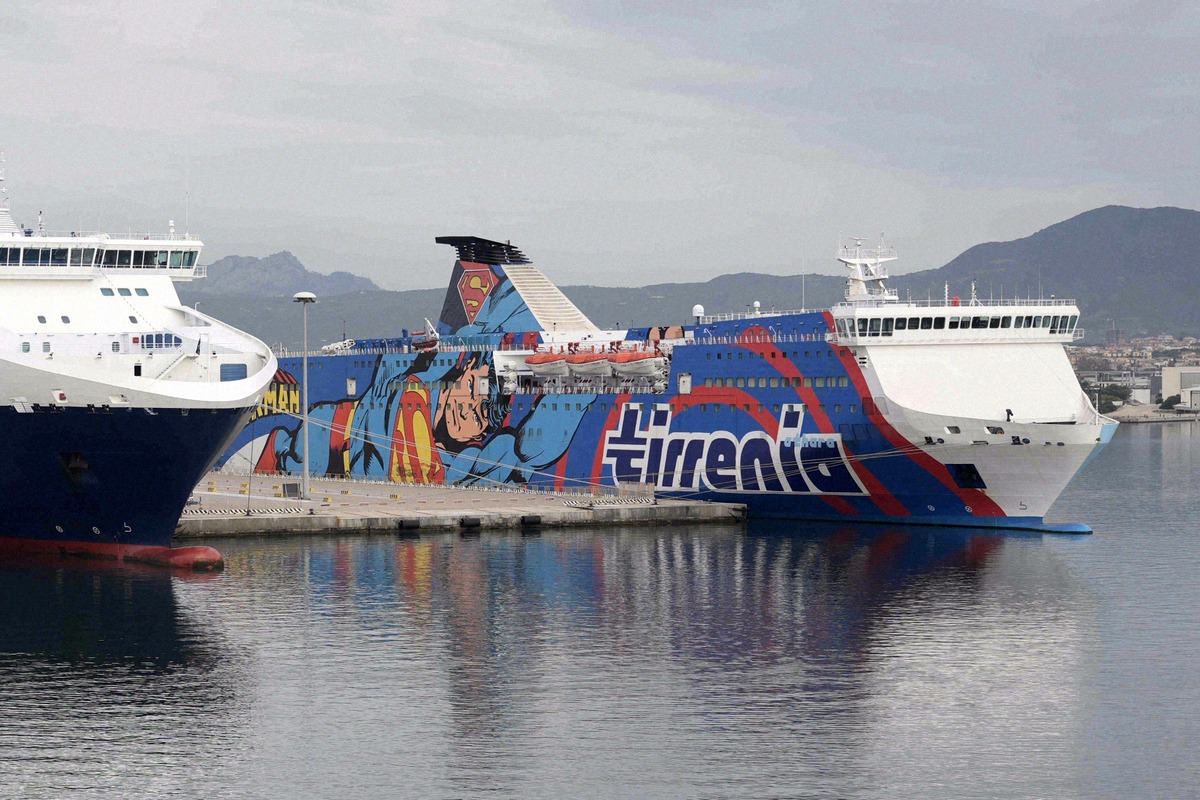 A Tirrenia ferry with a striking Superman comic livery moored in the port of Olbia