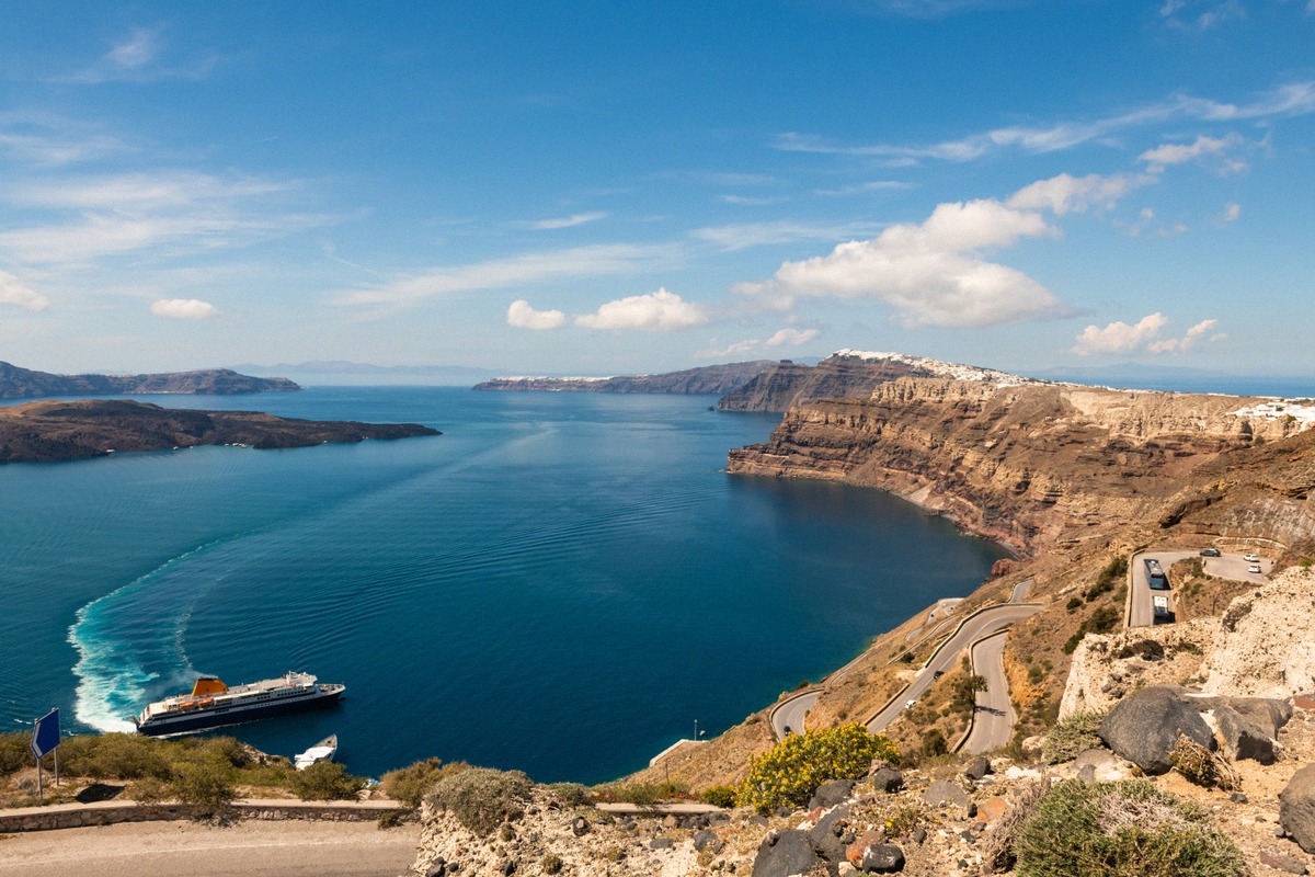 Panorama der Caldera von Santorin mit einer Fähre auf dem Kratermeer
