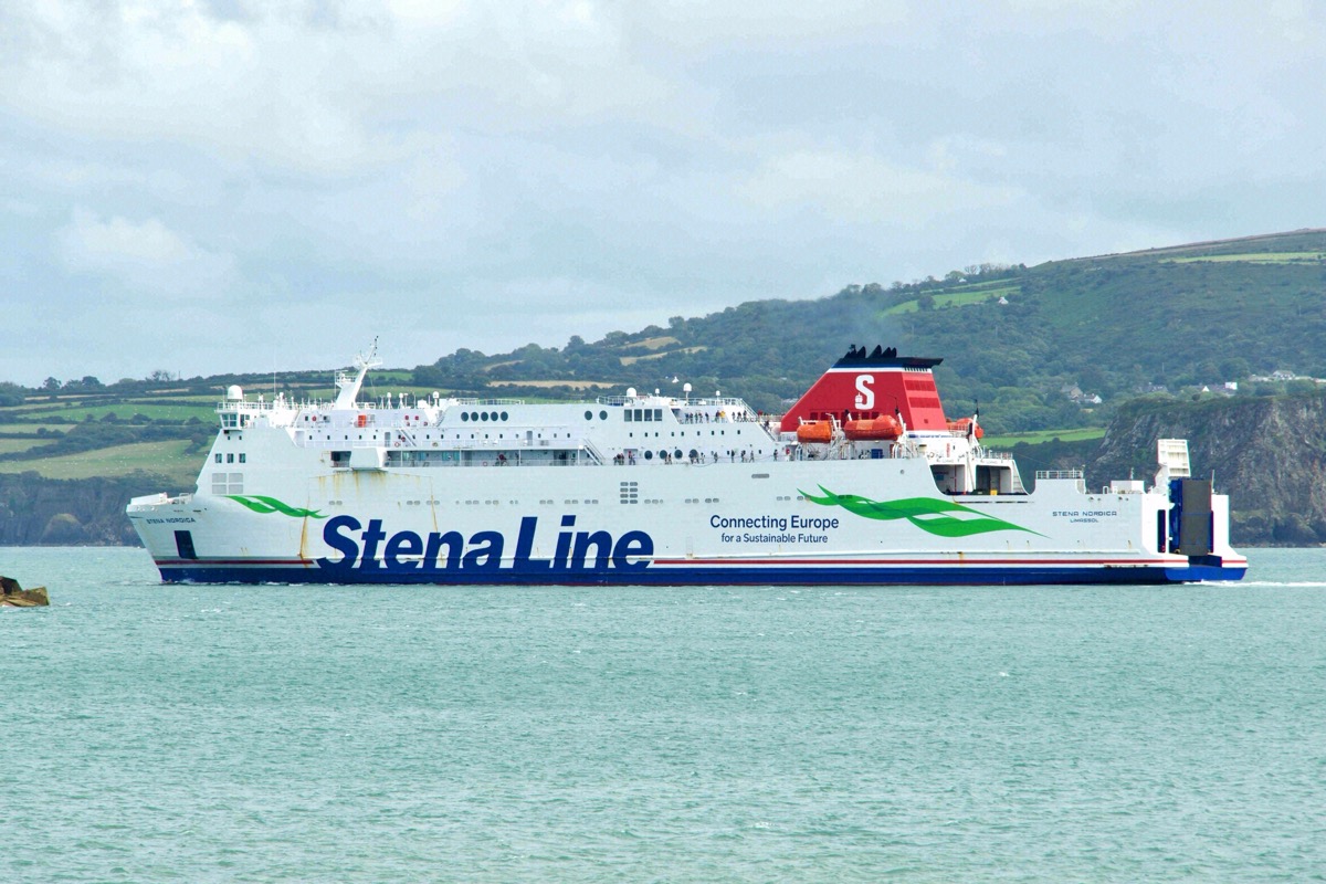 A Stena Line ferry sailing on the Irish Sea past a green coastline with cliffs
