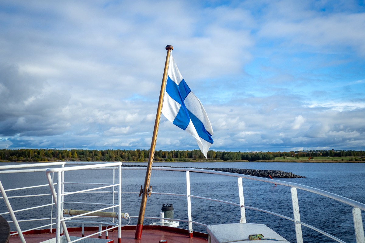 View from a ship's bow of the Finnish flag fluttering in the autumn wind