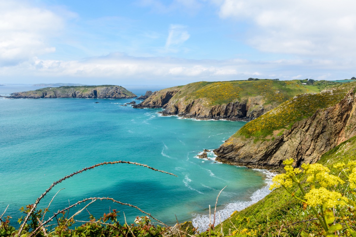 Dramatische Steilküste von Guernsey im Frühling mit türkisblauem Atlantik, felsigen Klippen
