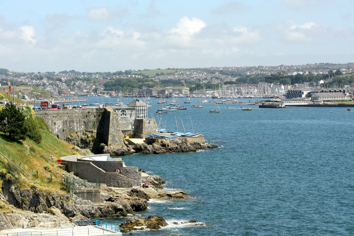 Blick über die Meeresbucht von Plymouth mit Stadtbefestigung, Segelbooten und dem Hafen im Hintergrund