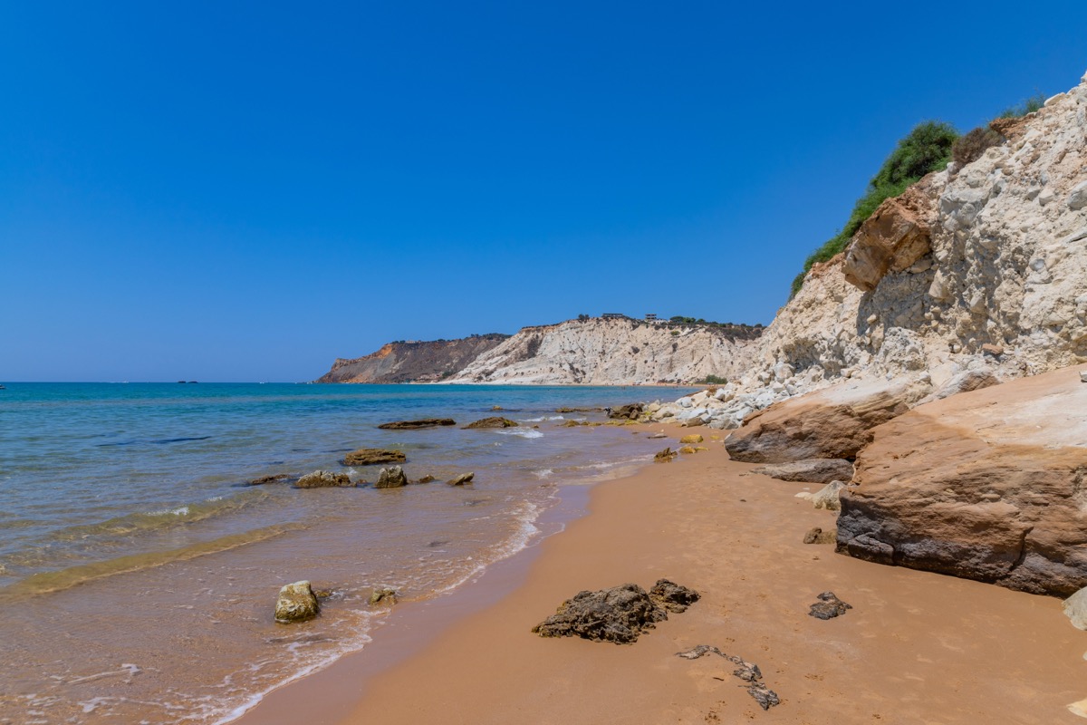 Bright cliffs and a sandy beach on the coast of Sicily