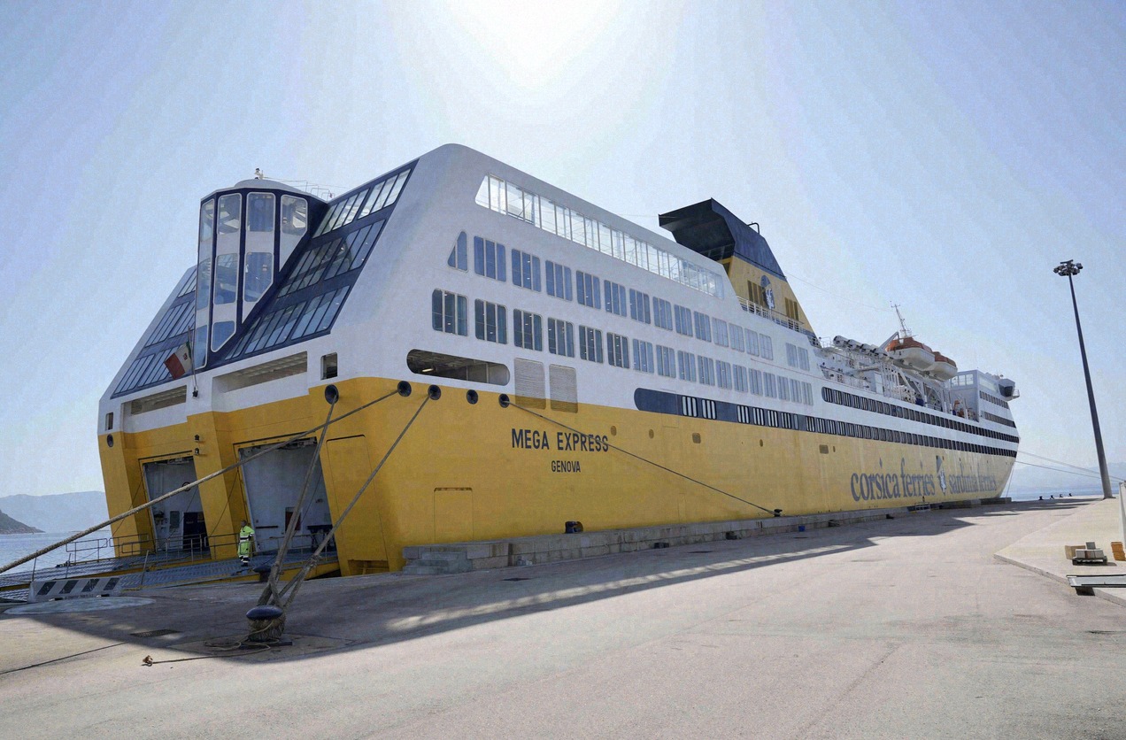 The yellow-and-white ferry 'Mega Express' of Corsica Ferries moored in the sun-drenched harbour
