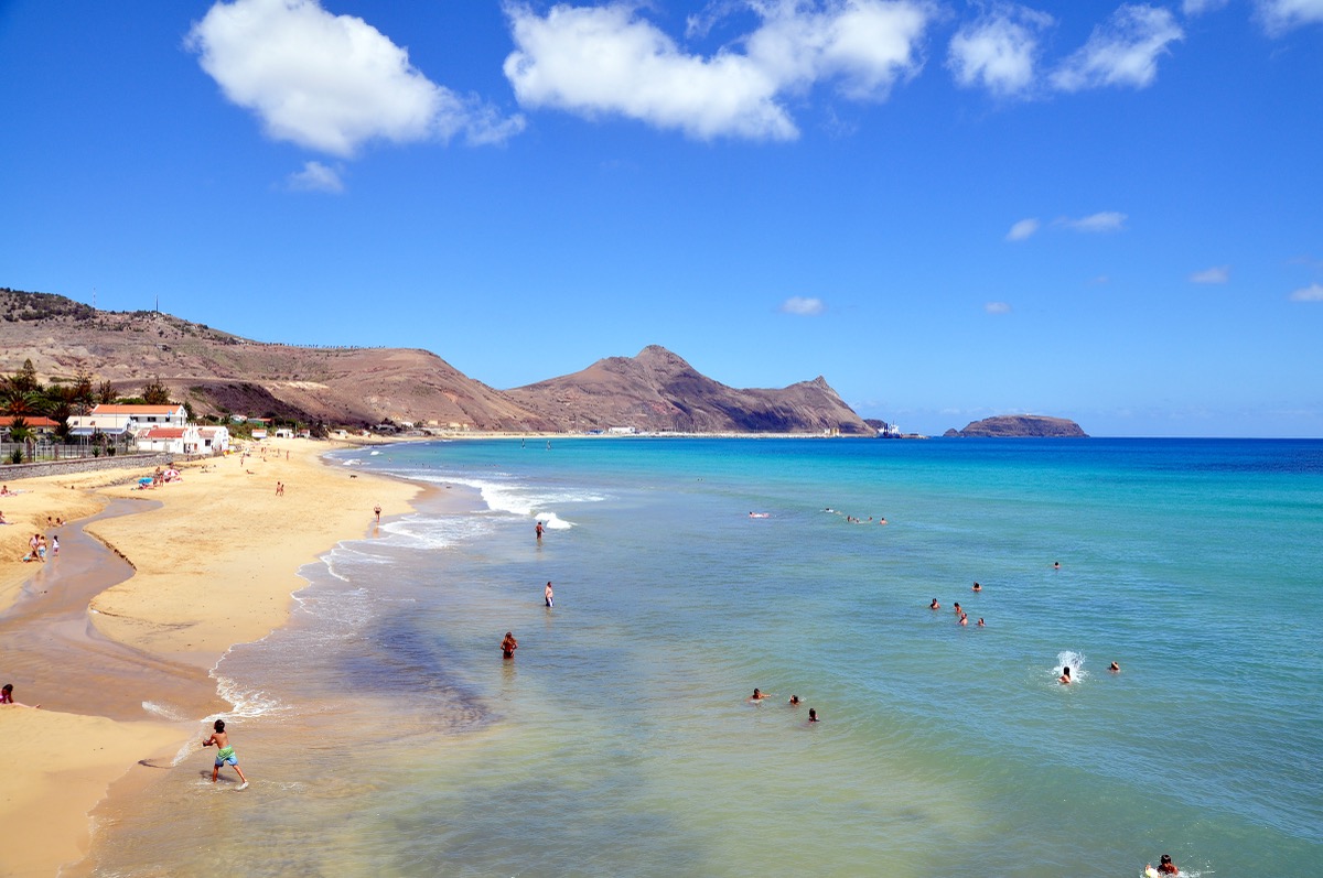 The nine-kilometer golden beach of Porto Santo, with turquoise water and bathers