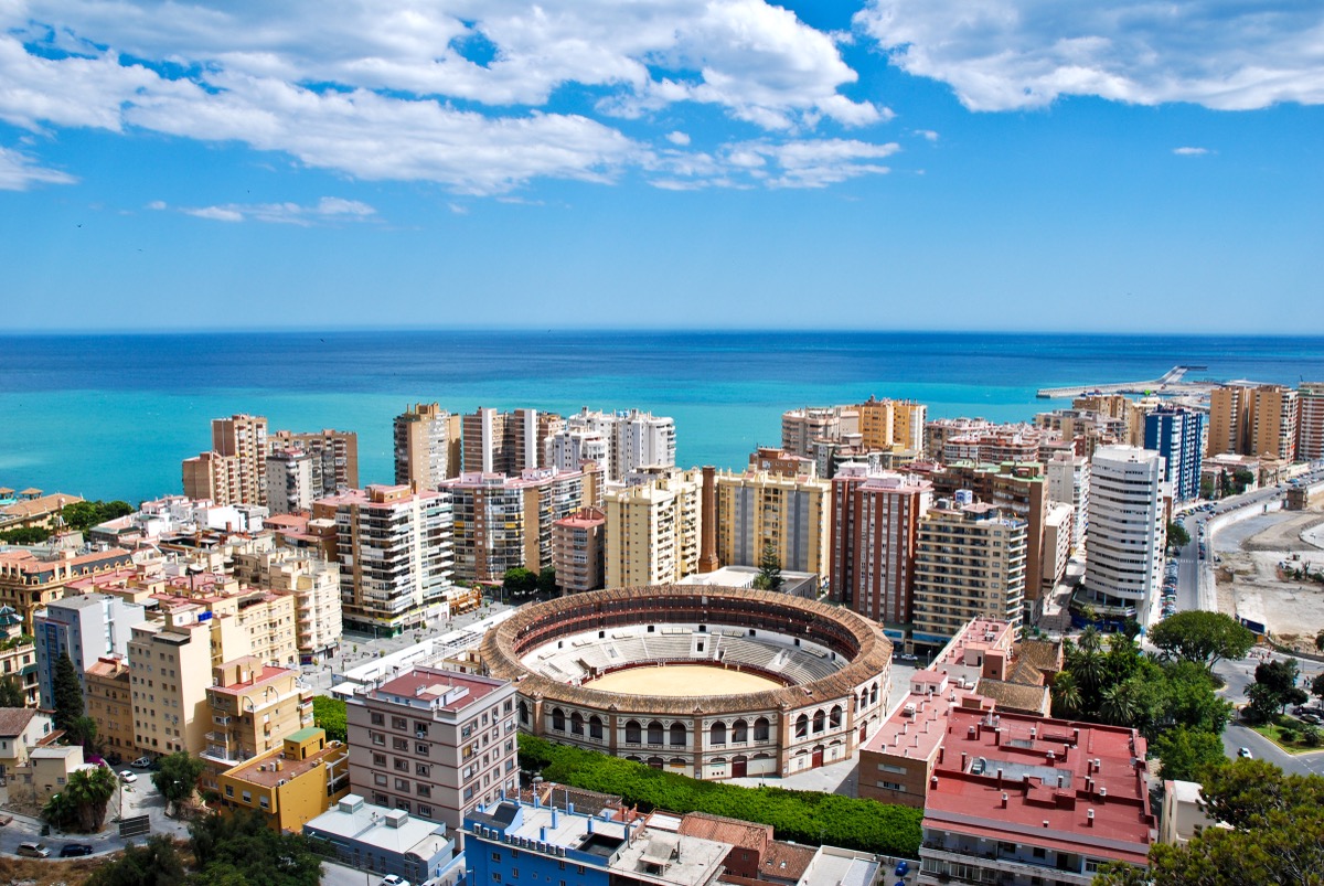Aerial panorama over Málaga with the distinctive round La Malagueta bullring in the foreground