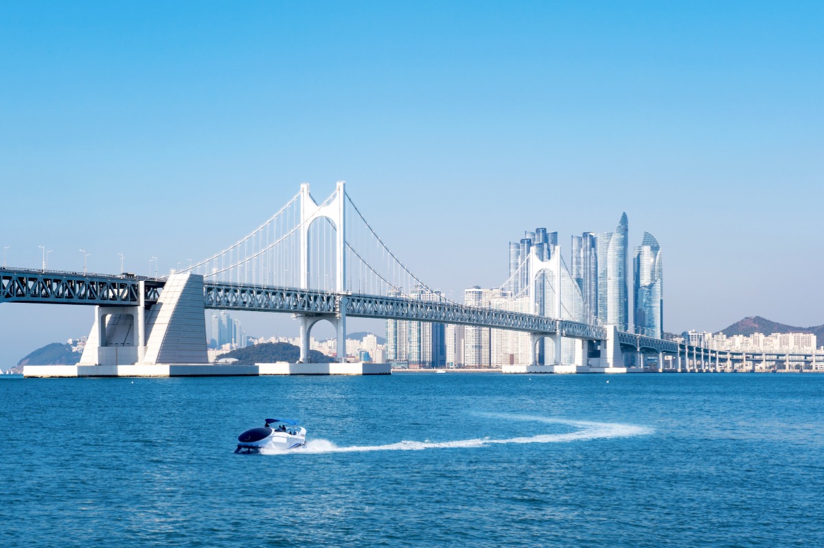 Gwangan Bridge in Busan with the Haeundae skyline and a boat on the water
