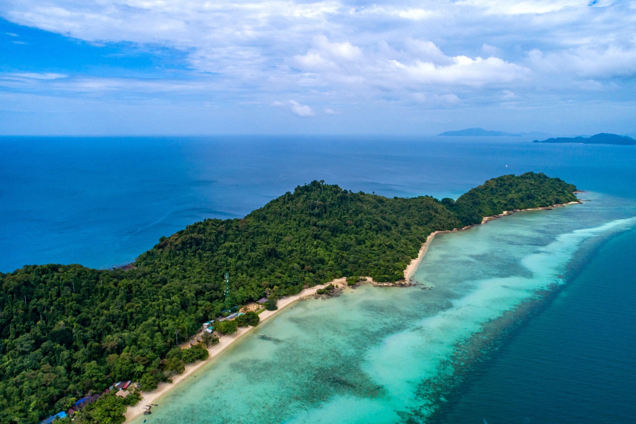 Drohnenaufnahme der tropischen Insel Koh Kradan: dichter Dschungel trifft auf weiße Sandstrände und ein strahlend türkisfarbenes