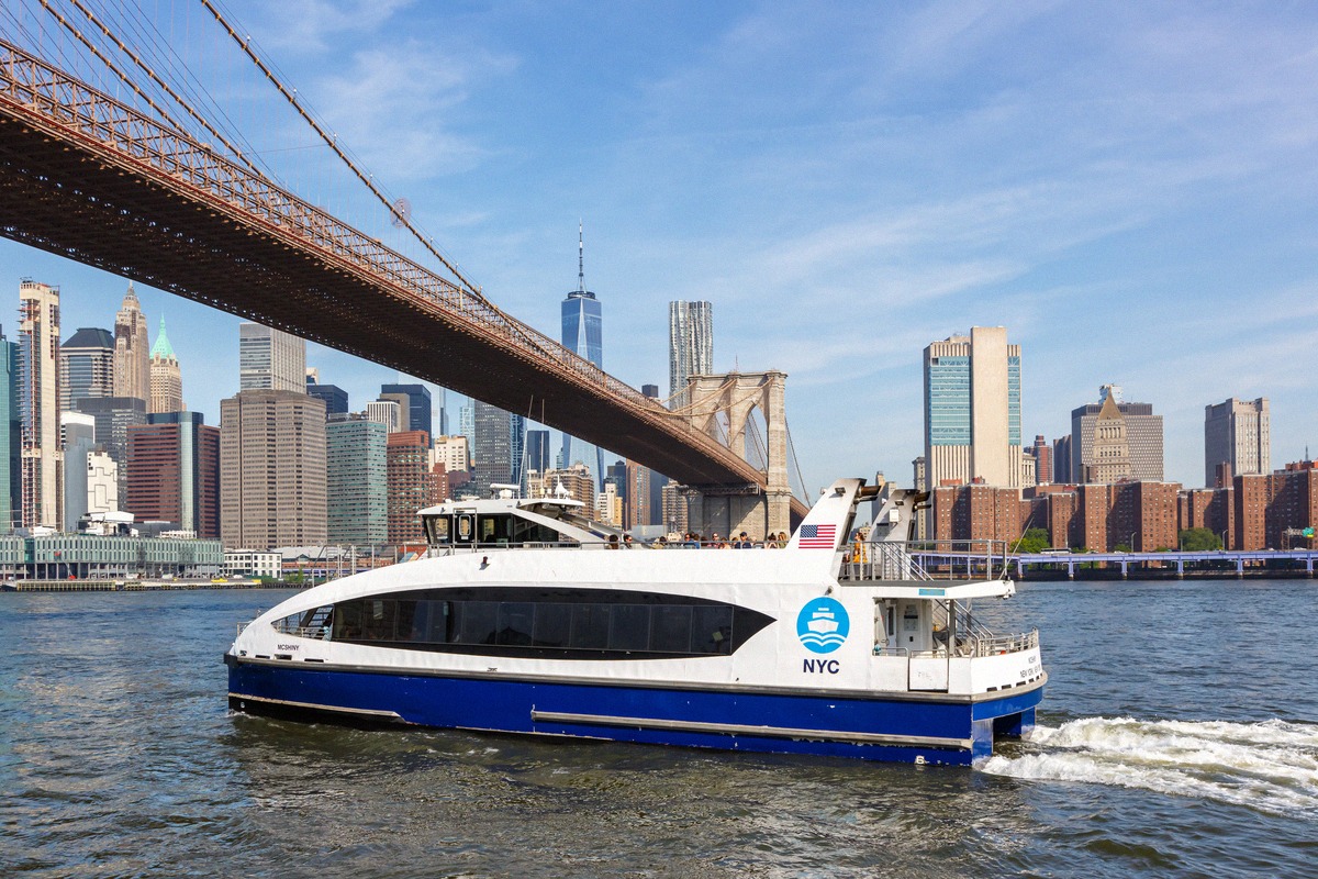 NYC-Ferry passiert die Brooklyn Bridge vor der Skyline Manhattans