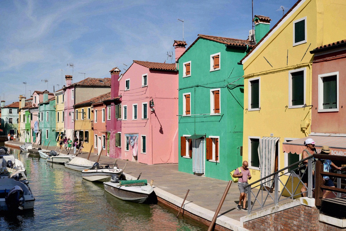 Pastellfarbene Häuser und Boote an einem Kanal auf Burano